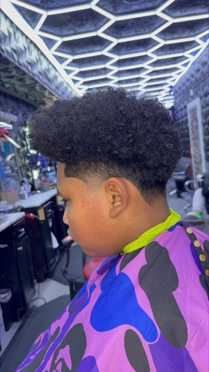Burst fade curving around the ear with a natural afro on top.