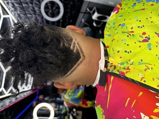 V design shaved on the nape with curls on top.
