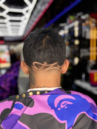 Freestyle design shaved on the nape over a skin fade.