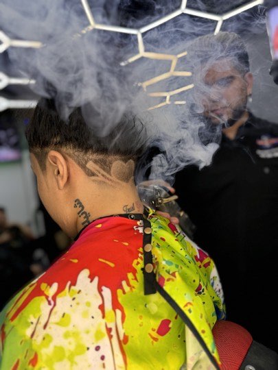 Geometric design shaved by hand on the side over a skin fade.