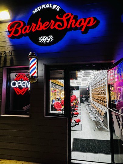 La entrada de Morales Barbershop MB, con la silla de masaje en la sala