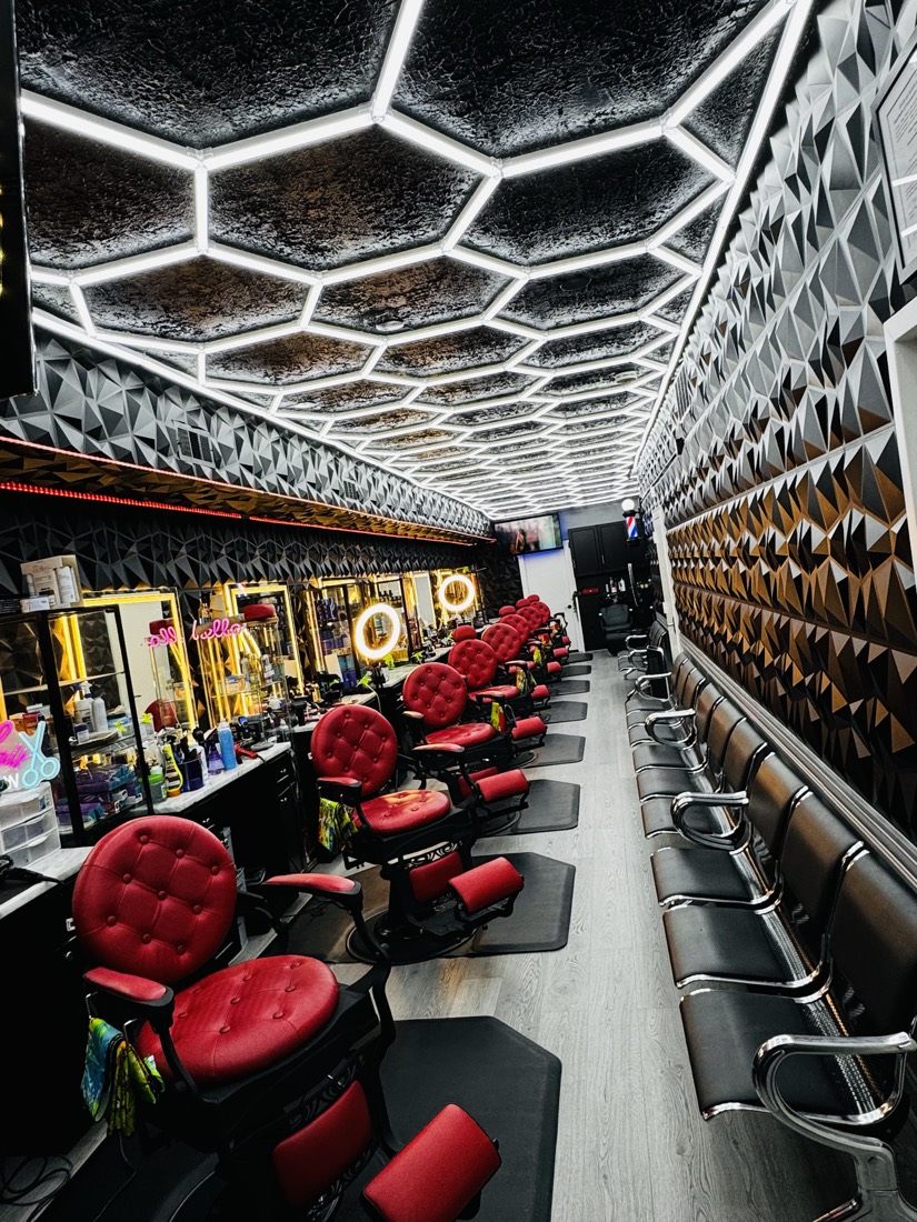 Row of barber stations with red chairs at Morales Barbershop MB.