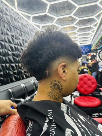Modern mullet with a burst fade around the ear and length in back.