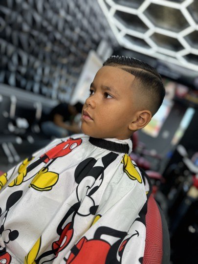 Niño con corte de fade alto y perfilado recto