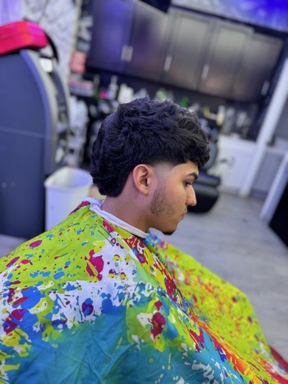 Natural waves on top with a mid fade and a light beard.