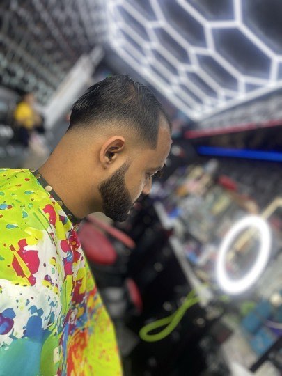 Skin fade with a tight full beard and a sharp line up.