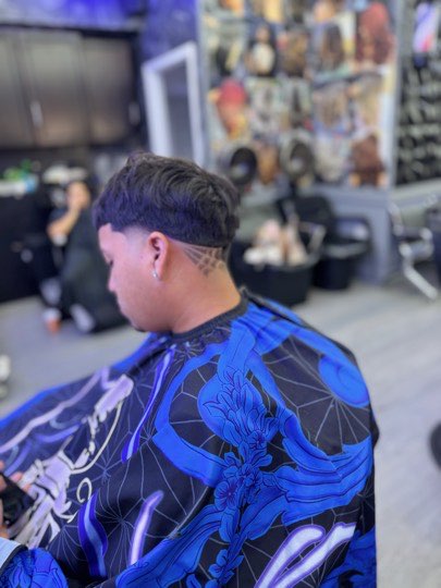 Taper bajo con una línea rapada sobre la oreja.