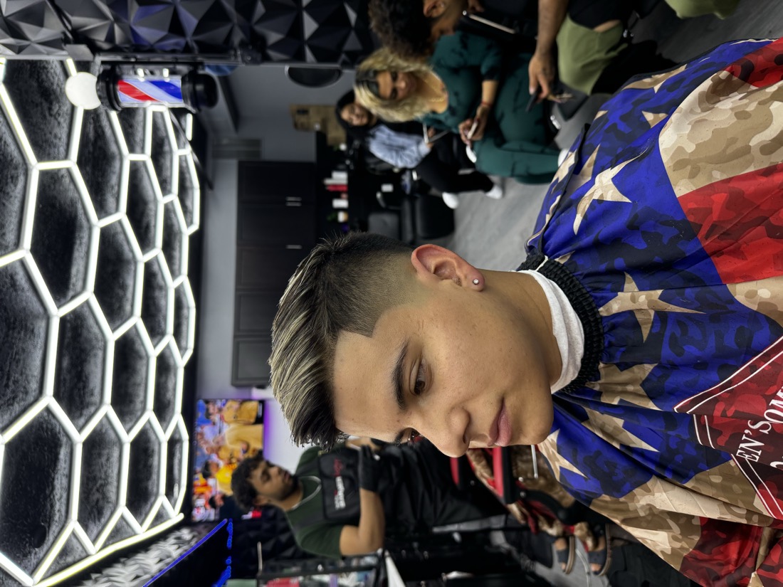 A client with a platinum bleached top and a skin fade on the sides, inside Morales Barbershop MB in Hyattsville.